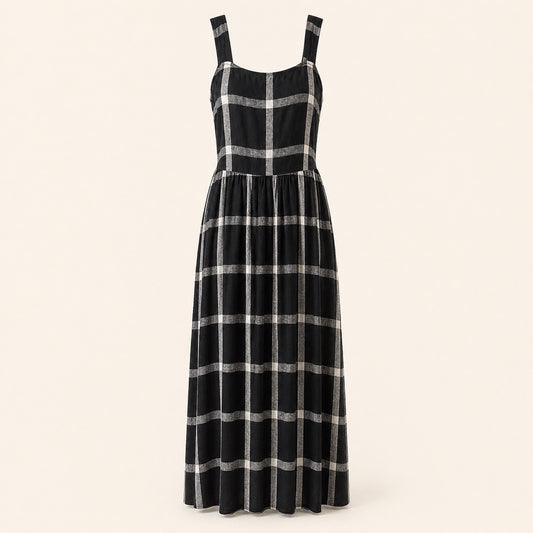 A sleeveless black midi dress with a silver metallic plaid pattern, featuring a structured bodice and wide shoulder straps, shown against a solid light beige background.