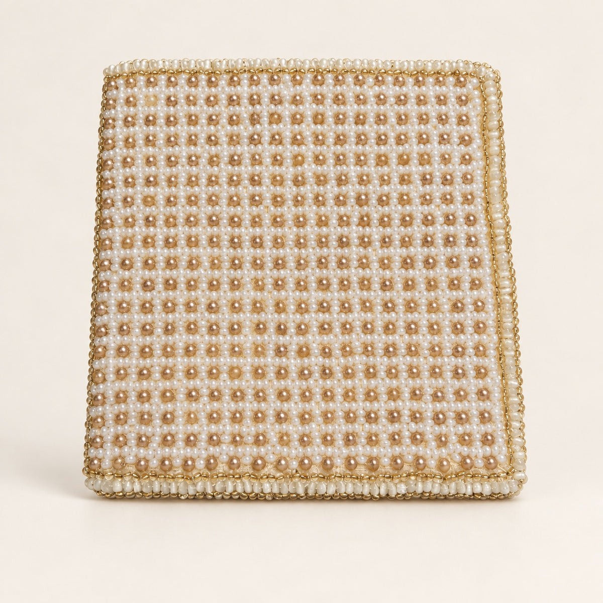 A square beaded clutch bag featuring a grid pattern of cream and gold faux pearls with a matching gold beaded border, set against a solid off-white background.