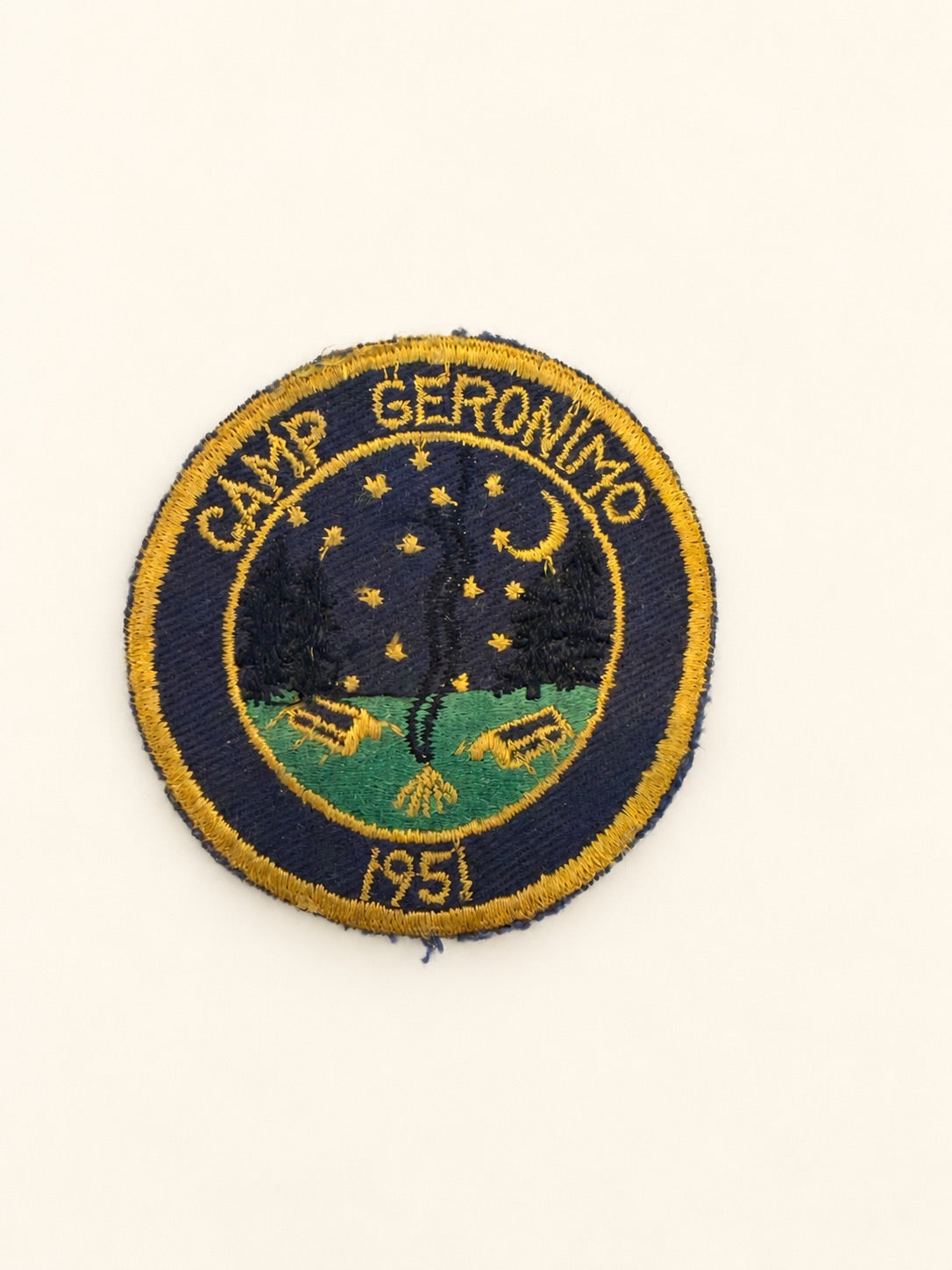 A circular embroidered patch for Camp Geronimo 1951, featuring a night sky with stars and a crescent moon above a campfire scene, on a cream-colored background.