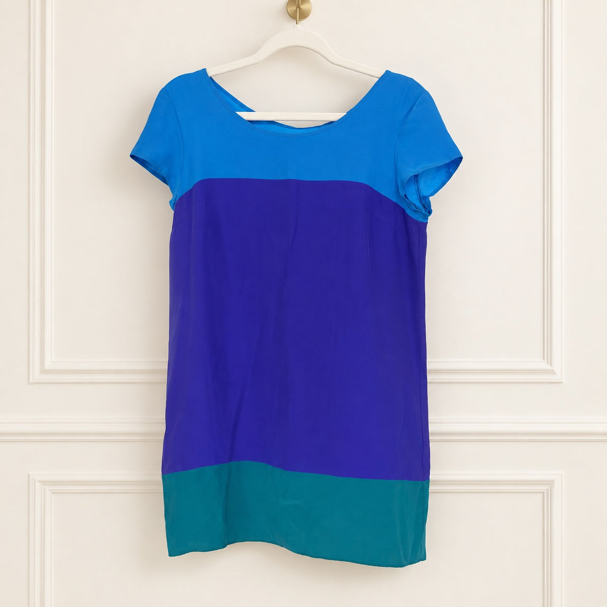A short-sleeve colorblock dress. The shirt features three color blocks: a bright blue top section, a wide purple middle section, and a teal bottom section.