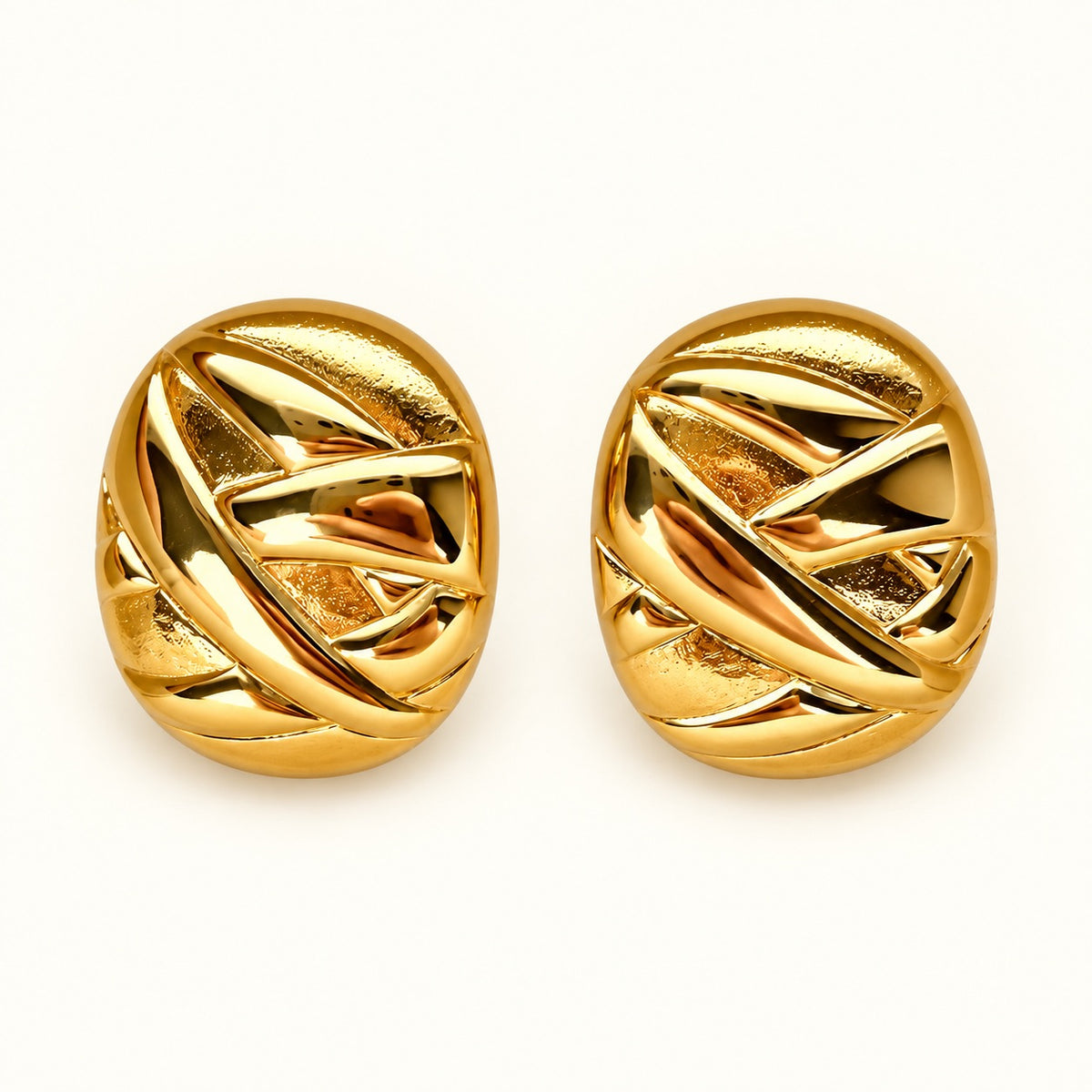 A pair of gold oval stud earrings with an interlocking, woven geometric design, shown on a clean white background.
