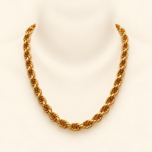 A chunky gold rope chain necklace displayed on a white mannequin neck against a light cream background.