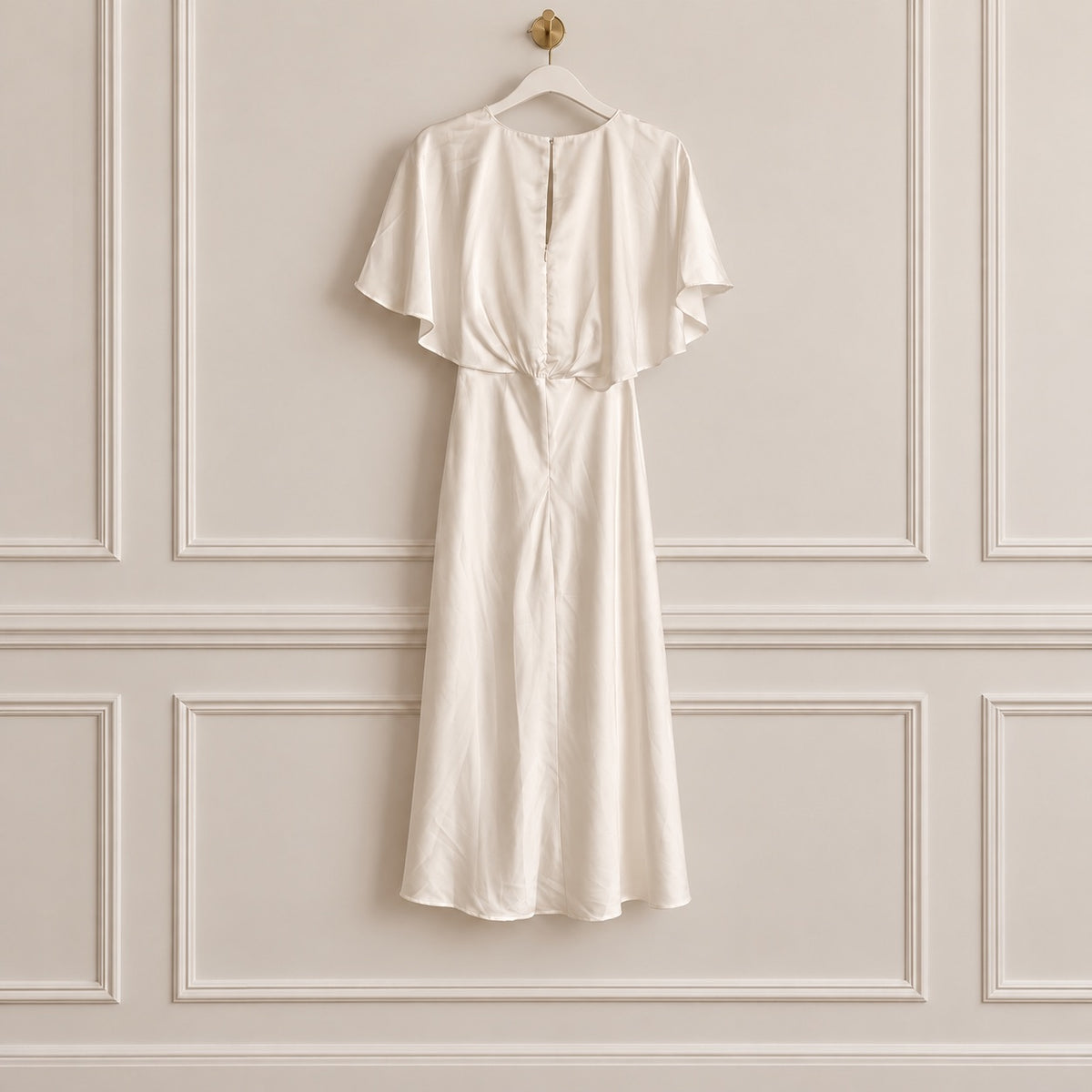 An ivory or cream-colored midi dress with short flutter sleeves and a gathered waist, hanging on a white hanger against a beige paneled wall.
