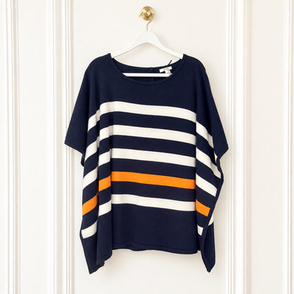 A navy blue short-sleeve top with wide horizontal white and orange stripes, hanging on a white hanger against a white paneled door.