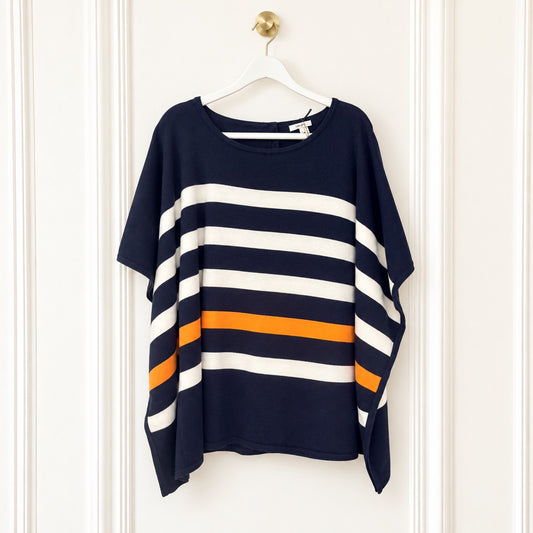 A navy blue short-sleeve top with wide horizontal white and orange stripes, hanging on a white hanger against a white paneled door.
