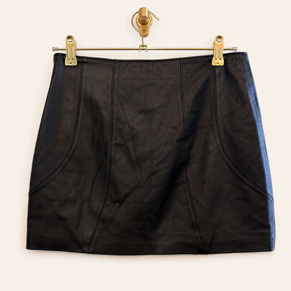 A black leather mini skirt, hanging from a gold-colored metal hanger with clips against a plain off-white background.