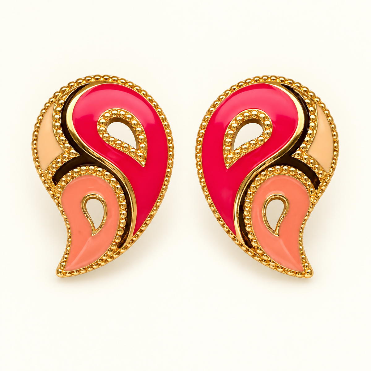 A pair of ornate paisley-shaped earrings with vibrant pink, coral pink, and peach enamel sections outlined in gold-tone metal with beaded borders, set against a plain white background.